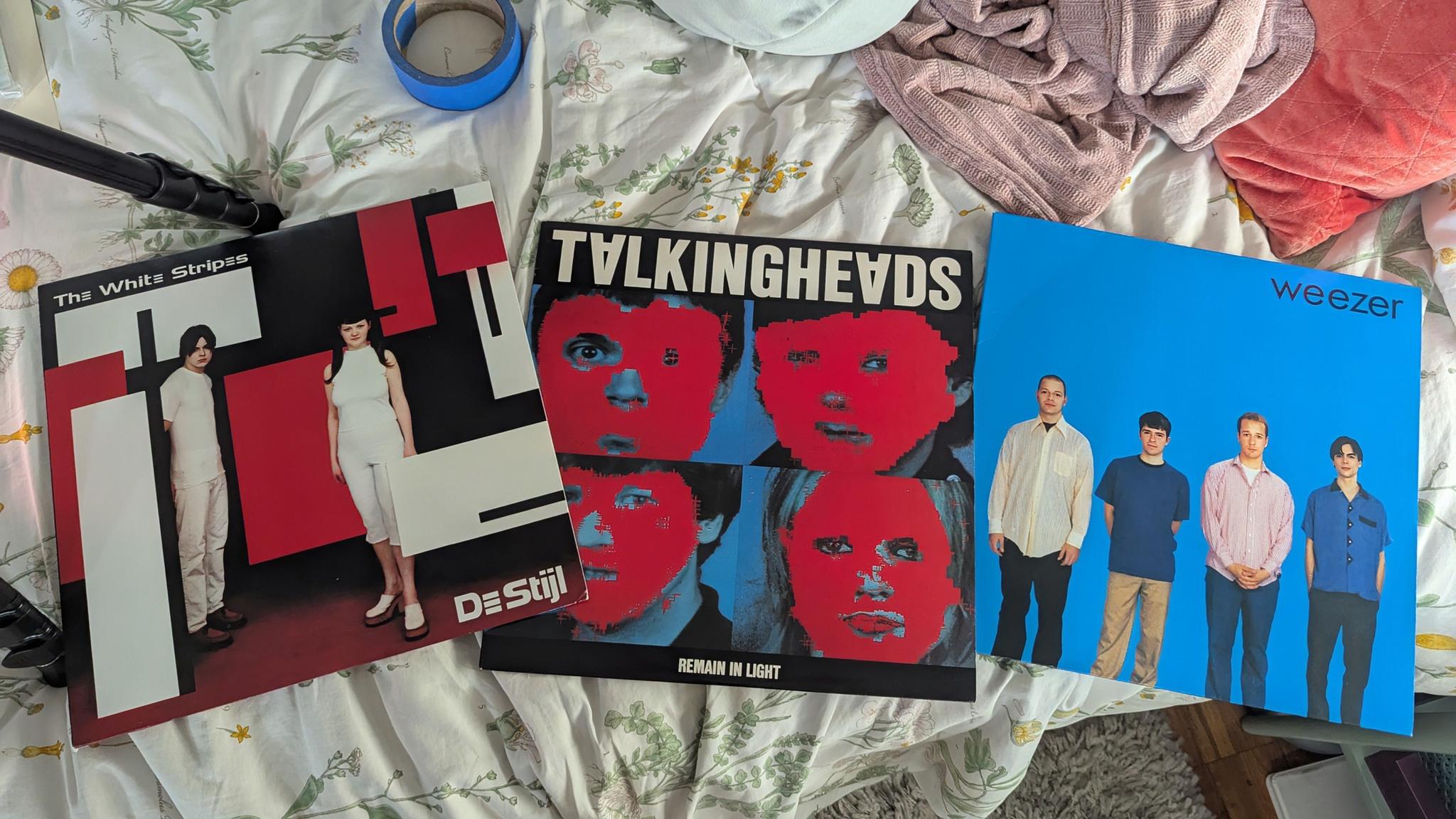 aerial view of three vinyl album covers sitting on a bed.